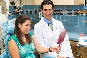 patient at looks at self in mirror at dental office