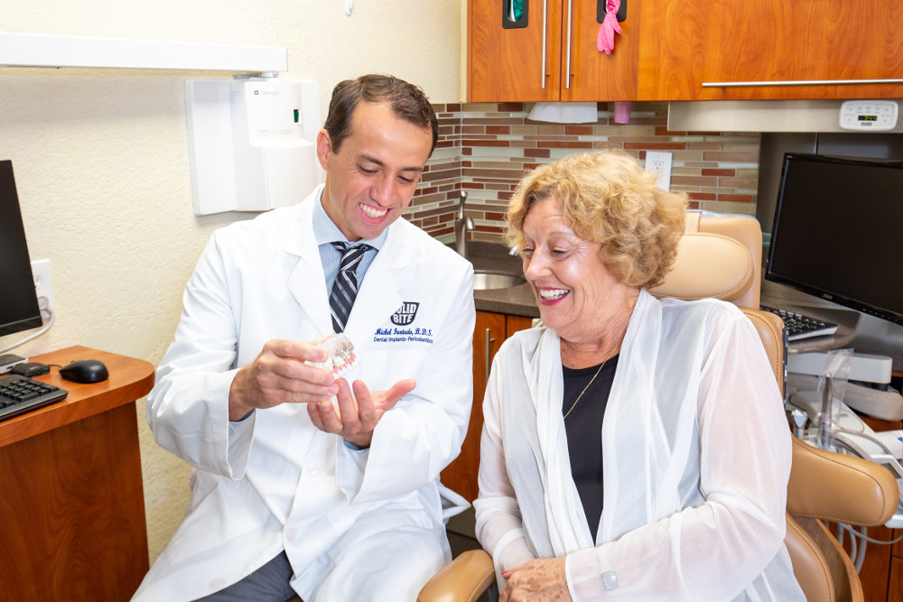 dentist explains denture stabilization to female patient