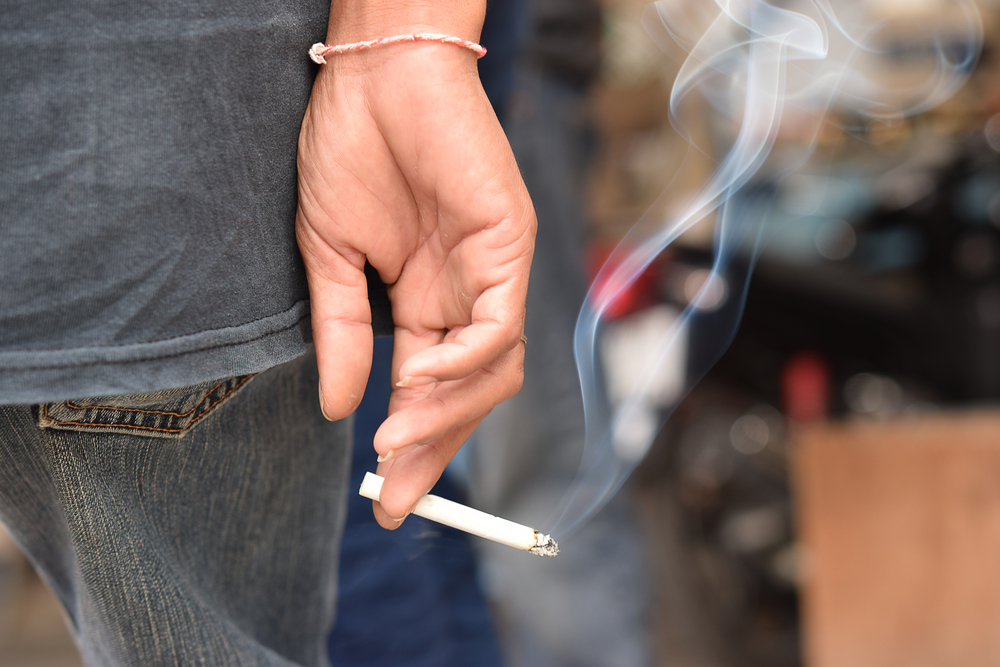 burning cigarette in someone's hand