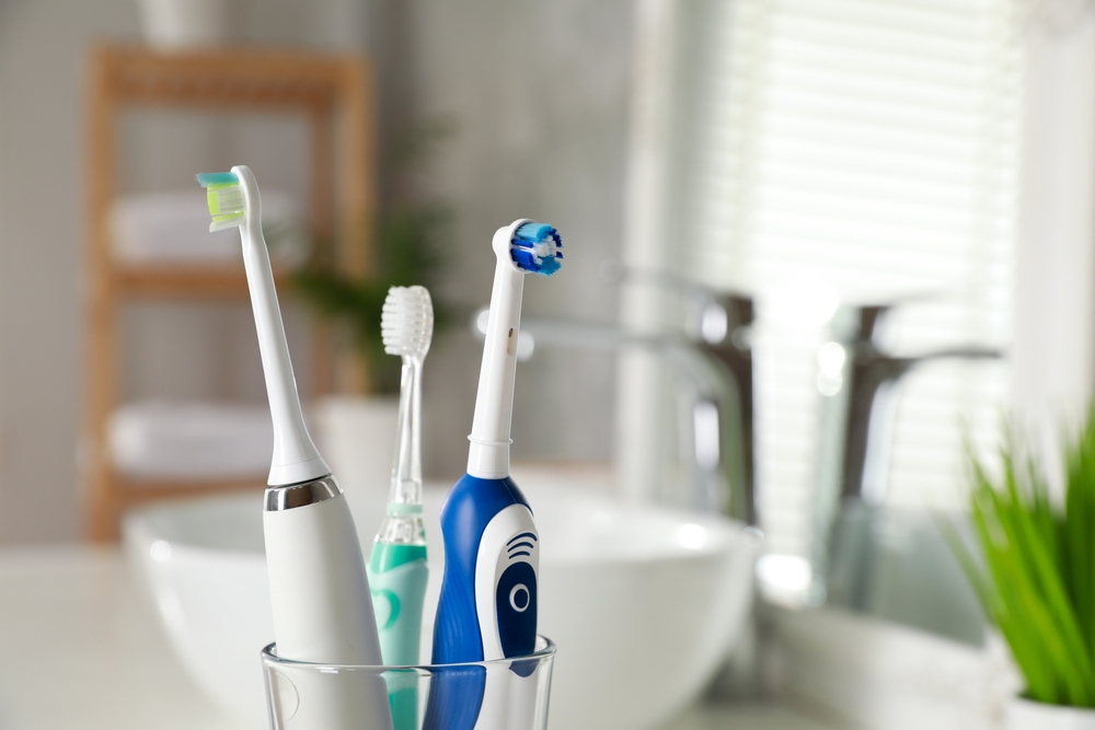 different electric toothbrushes in glass container