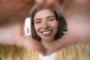 woman smiling through a heart