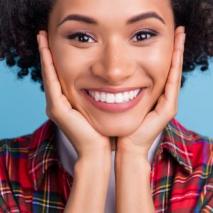 young woman wearing flannel has a big smile
