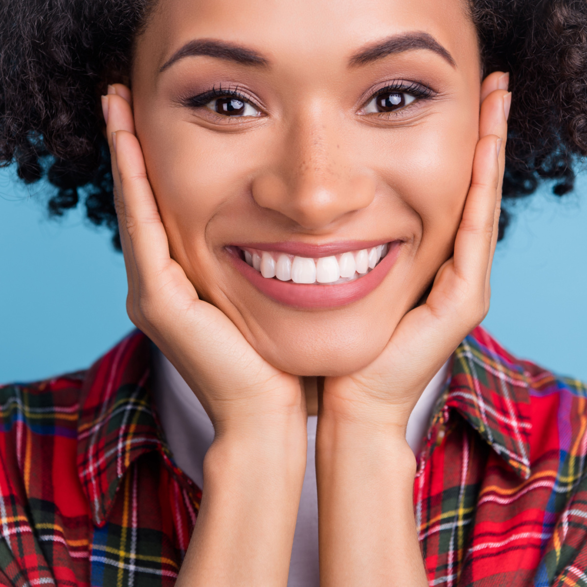 young woman wearing flannel has a big smile