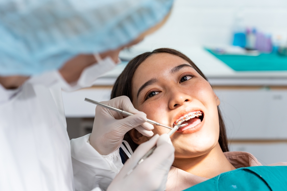woman wearing braces gets dental exam